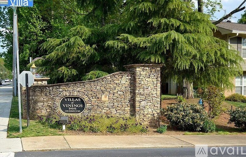 A stone wall with a sign that says Villas Vining.