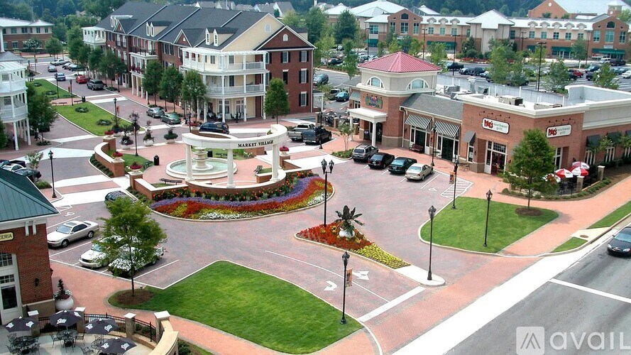 A small town square with a fountain in the middle.