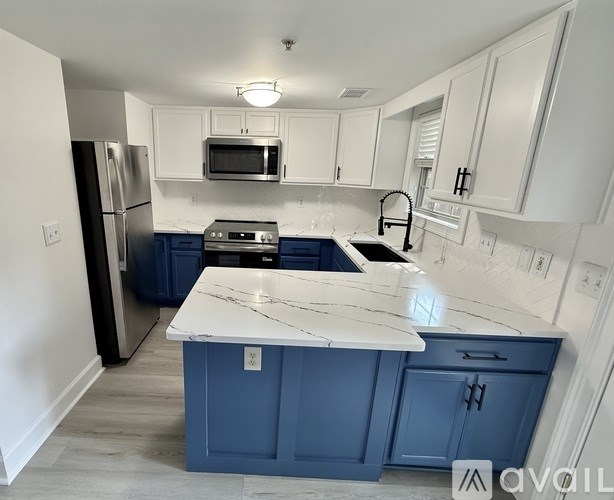 A kitchen with a white countertop and blue cabinets.