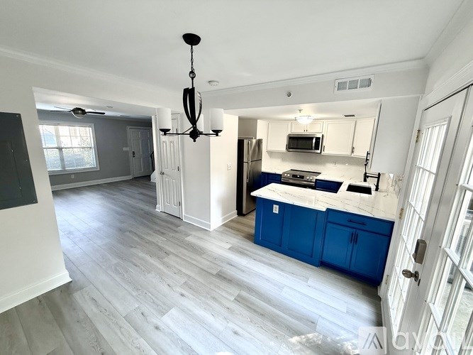 A kitchen with a blue island and white cabinets.