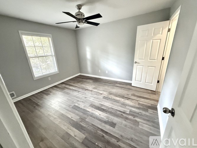 A room with a ceiling fan and a door.