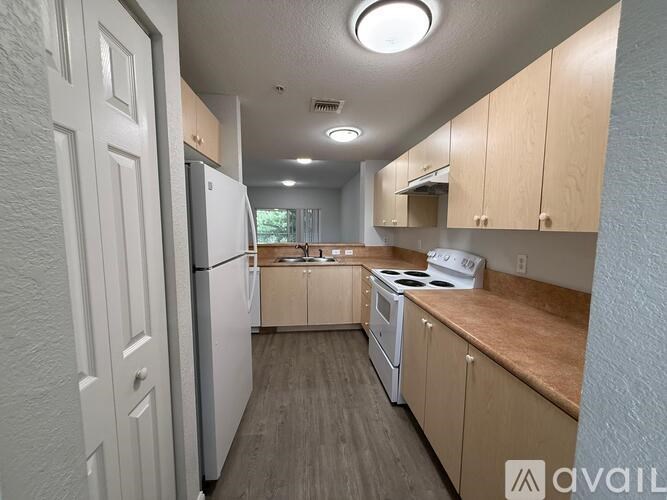 A kitchen with white appliances and wooden cabinets.