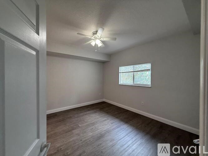 A room with a window and a ceiling fan.
