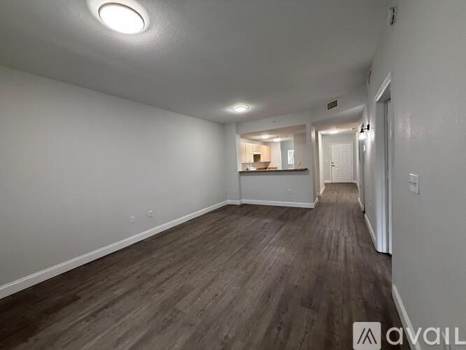 A room with wooden flooring and white walls.