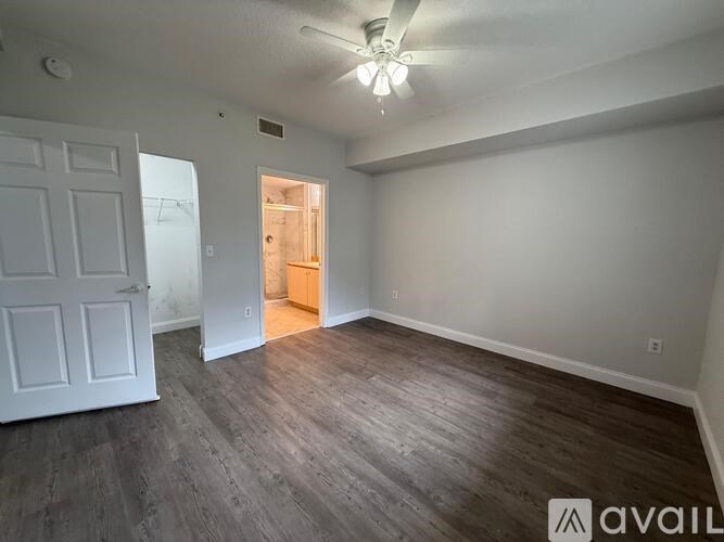 A room with wooden flooring and a white door.