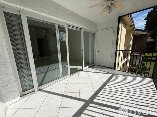 A patio with a ceiling fan and sliding glass doors.