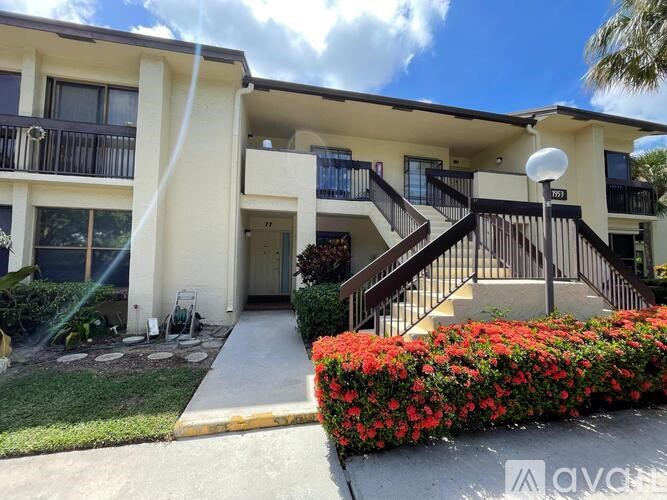 A building with a balcony and a staircase leading to the entrance.