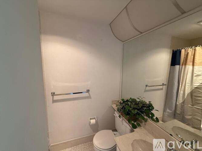 A bathroom with a toilet, sink, and mirror.