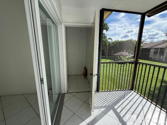 A view from inside a room looking out onto a balcony with a black railing.