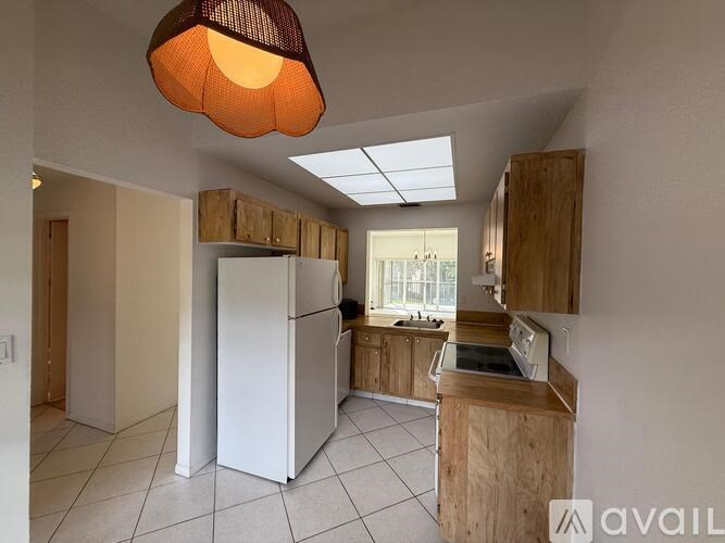 A kitchen with a white fridge and wooden cabinets.