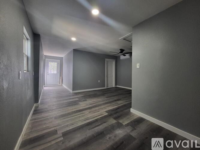 A room with wooden flooring and a ceiling fan.