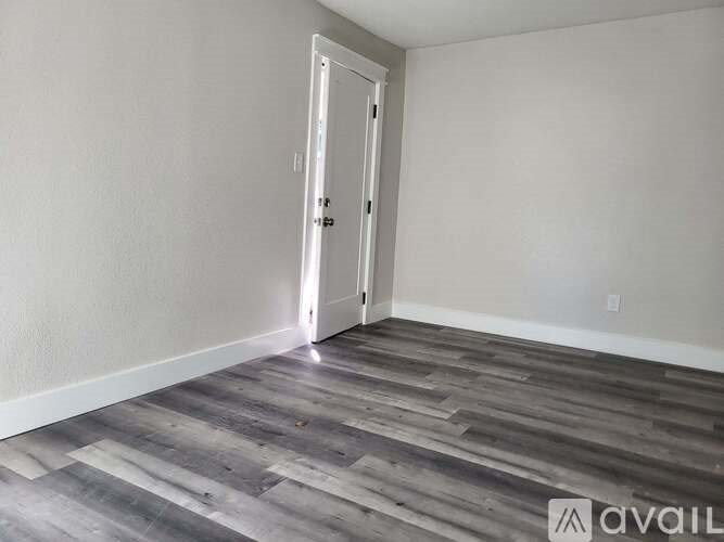 A room with a wooden floor and a white door.