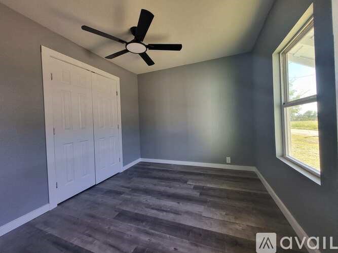 A room with a ceiling fan and a door.