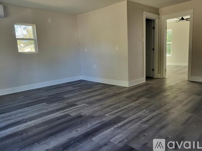A room with wooden flooring and a window.