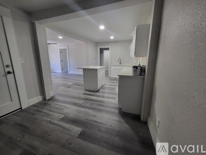 A spacious room with a kitchen island in the middle.