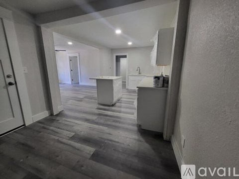 A spacious room with a kitchen island in the middle.