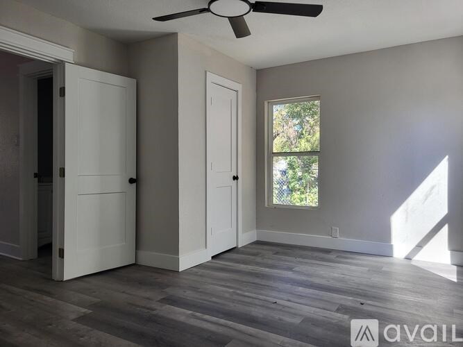 A room with a ceiling fan and two doors.