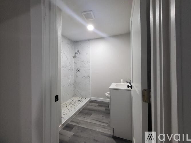A bathroom with a marble wall and a white sink.
