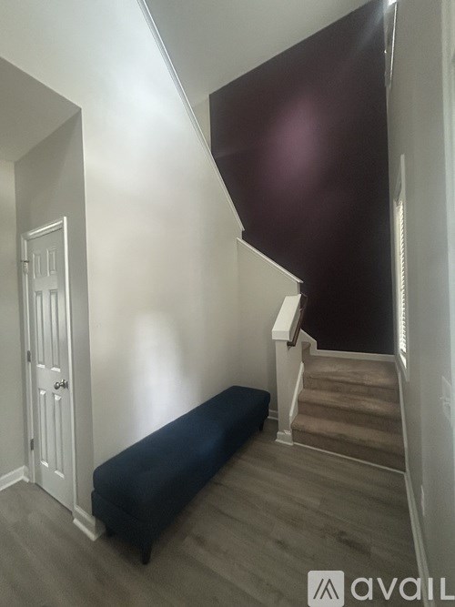 A hallway with a bench and a staircase.