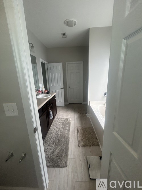 A hallway with a rug on the floor and a door on the right.