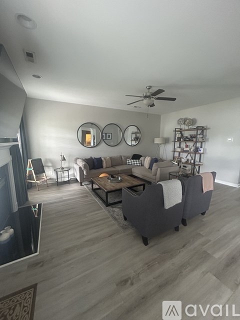 A living room with a grey couch and a wooden floor.