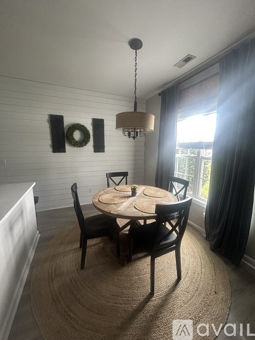 A dining room with a round table and chairs.