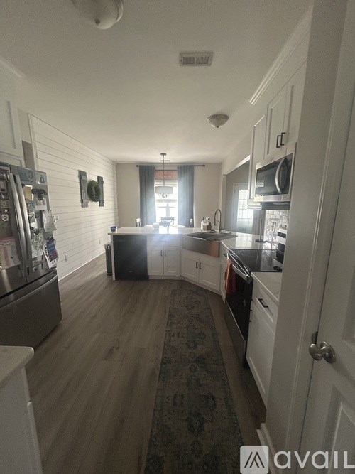 A kitchen with white cabinets and a black stove top.