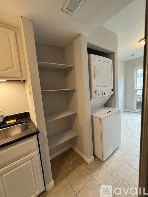 A kitchen with a white fridge and a sink.