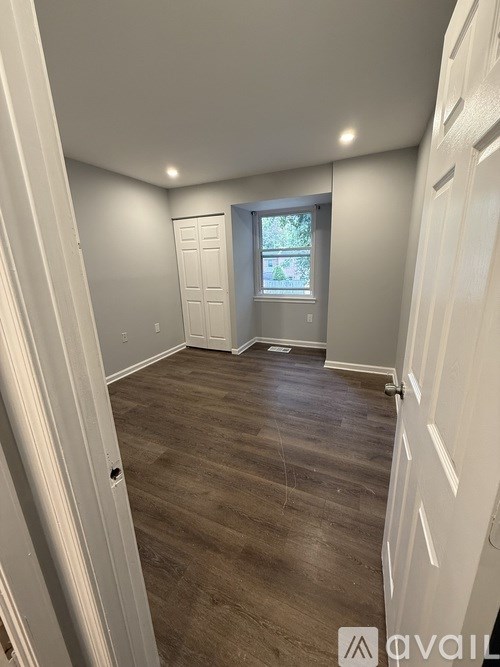 A room with wooden flooring and white walls.