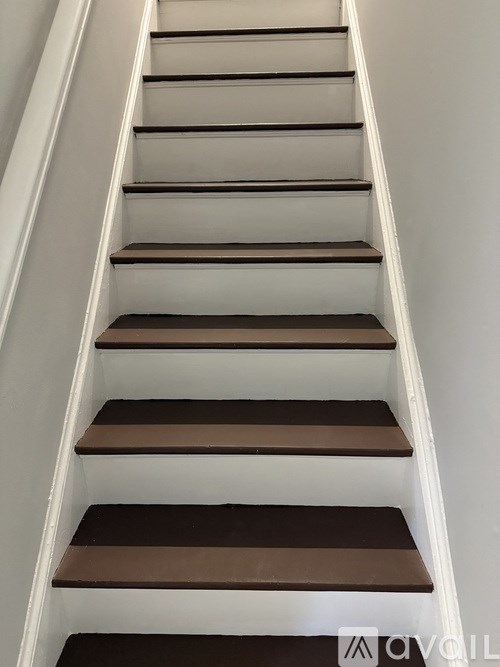 A set of stairs with alternating light and dark brown treads.