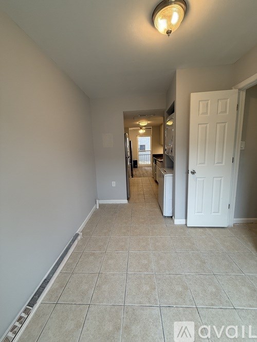 A hallway with a white door and a light on the ceiling.