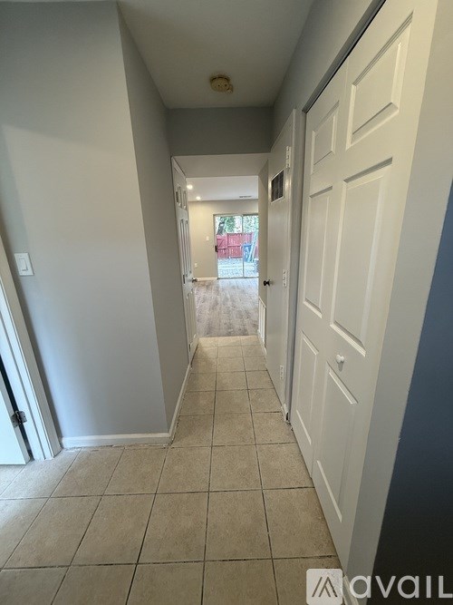 A hallway with white doors and tiled flooring.