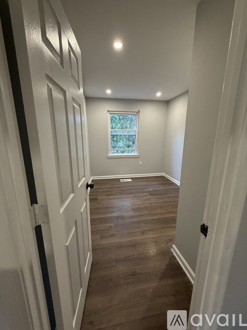 A hallway with wood floors and white walls.