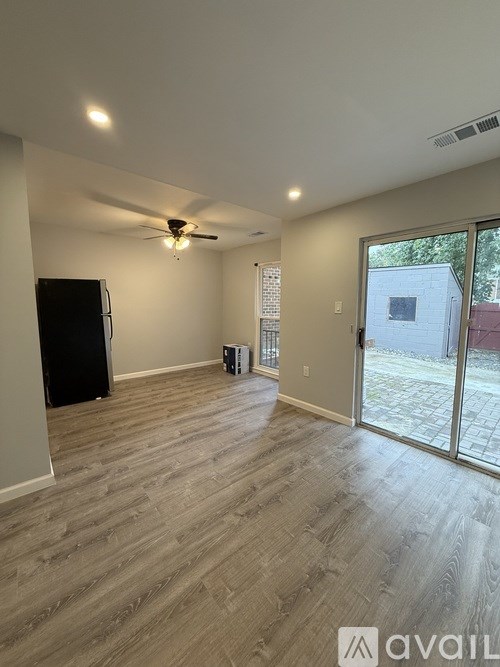 A room with a ceiling fan and sliding glass doors.