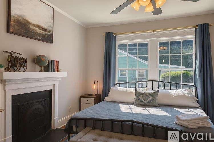 A bedroom with a large bed and a fireplace.