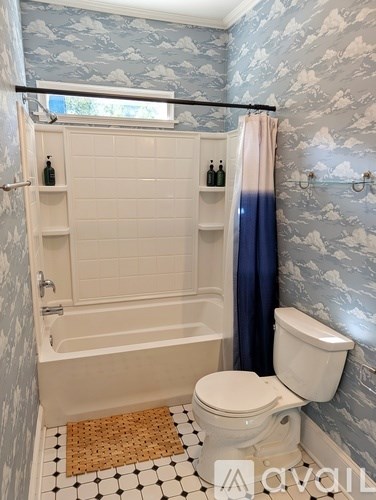 A bathroom with a toilet, tub, and shower.