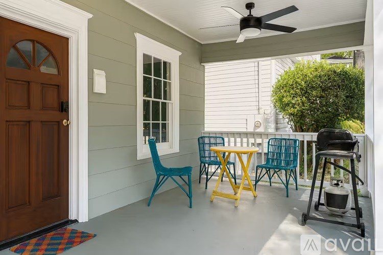 A patio with a table and chairs and a ceiling fan.