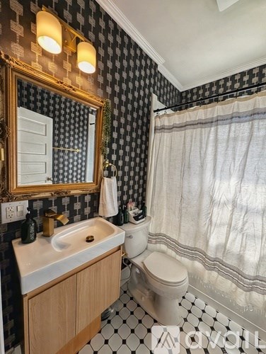 A bathroom with a sink, toilet and mirror.