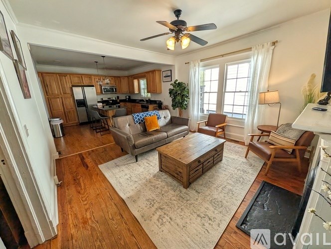 A living room with a wooden floor and a ceiling fan.