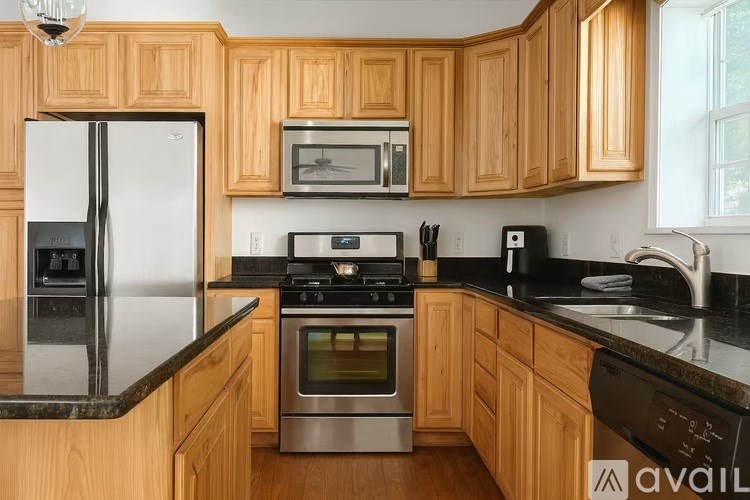 A kitchen with wooden cabinets and a black countertop.