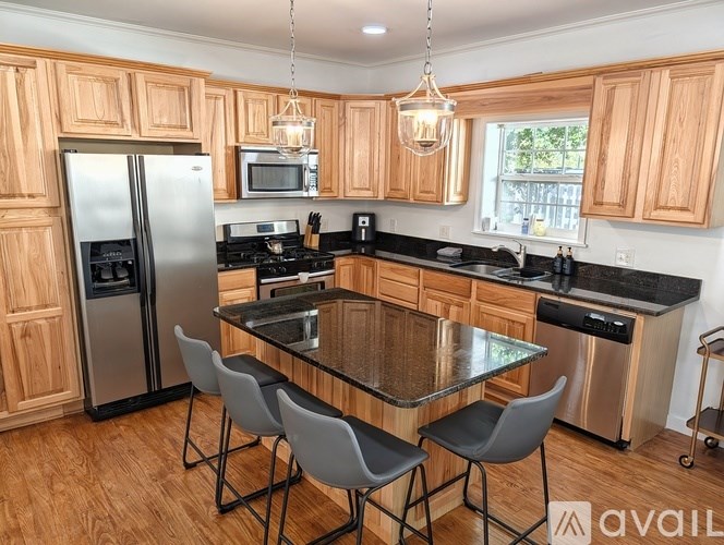 A kitchen with wooden cabinets and a glass table.