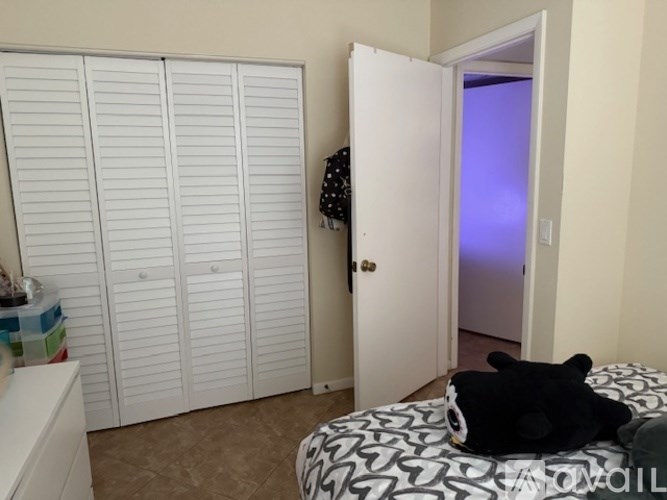 A room with a bed, a wardrobe and a door.