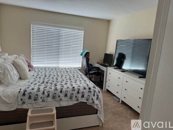 A bedroom with a bed, desk, and chair.