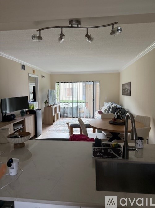 A kitchen with a black counter top and a television.