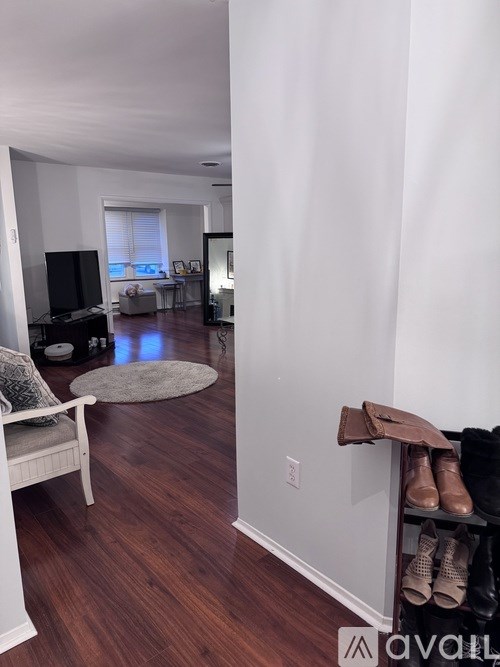 A living room with a white chair and a television.