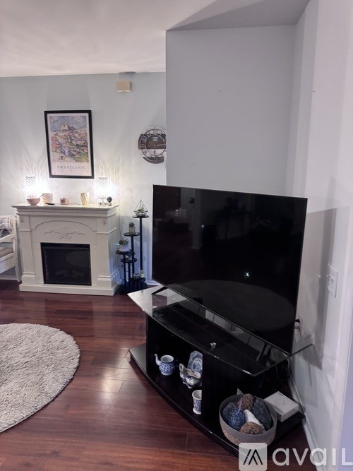 A living room with a fireplace and a flat screen TV.