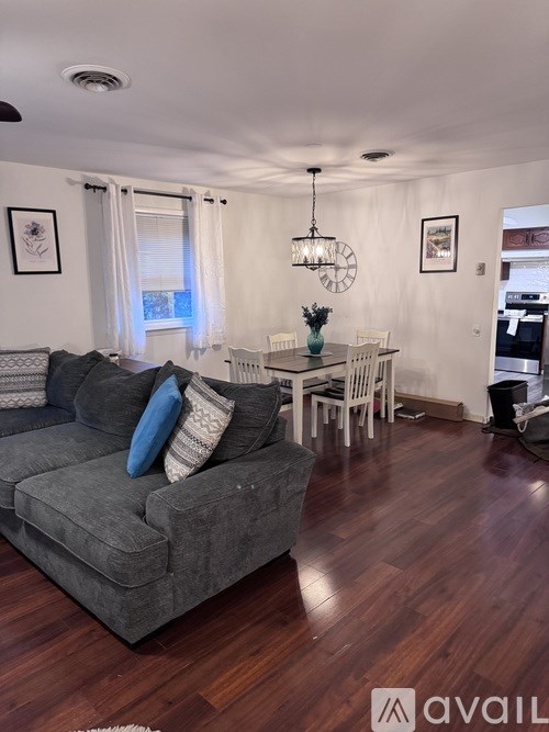 A living room with a grey couch and a wooden floor.