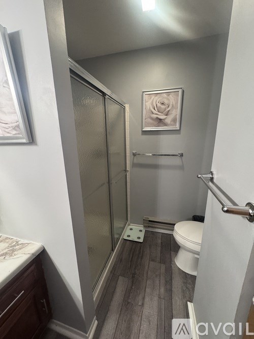 A bathroom with a toilet, a sink, and a shower stall.