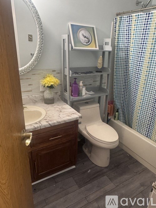 A bathroom with a toilet, sink, and shower.