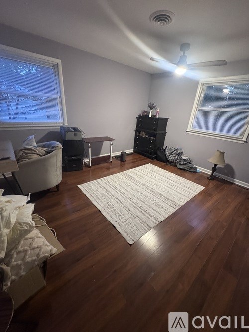 A room with a rug in the middle of the wooden floor.
